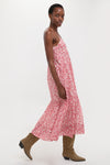 Effortlessly chic, the Red Sabba Dress features a classic, tiered silhouette and red floral print, styled with fun, high-end cowboy boots for any occasion.