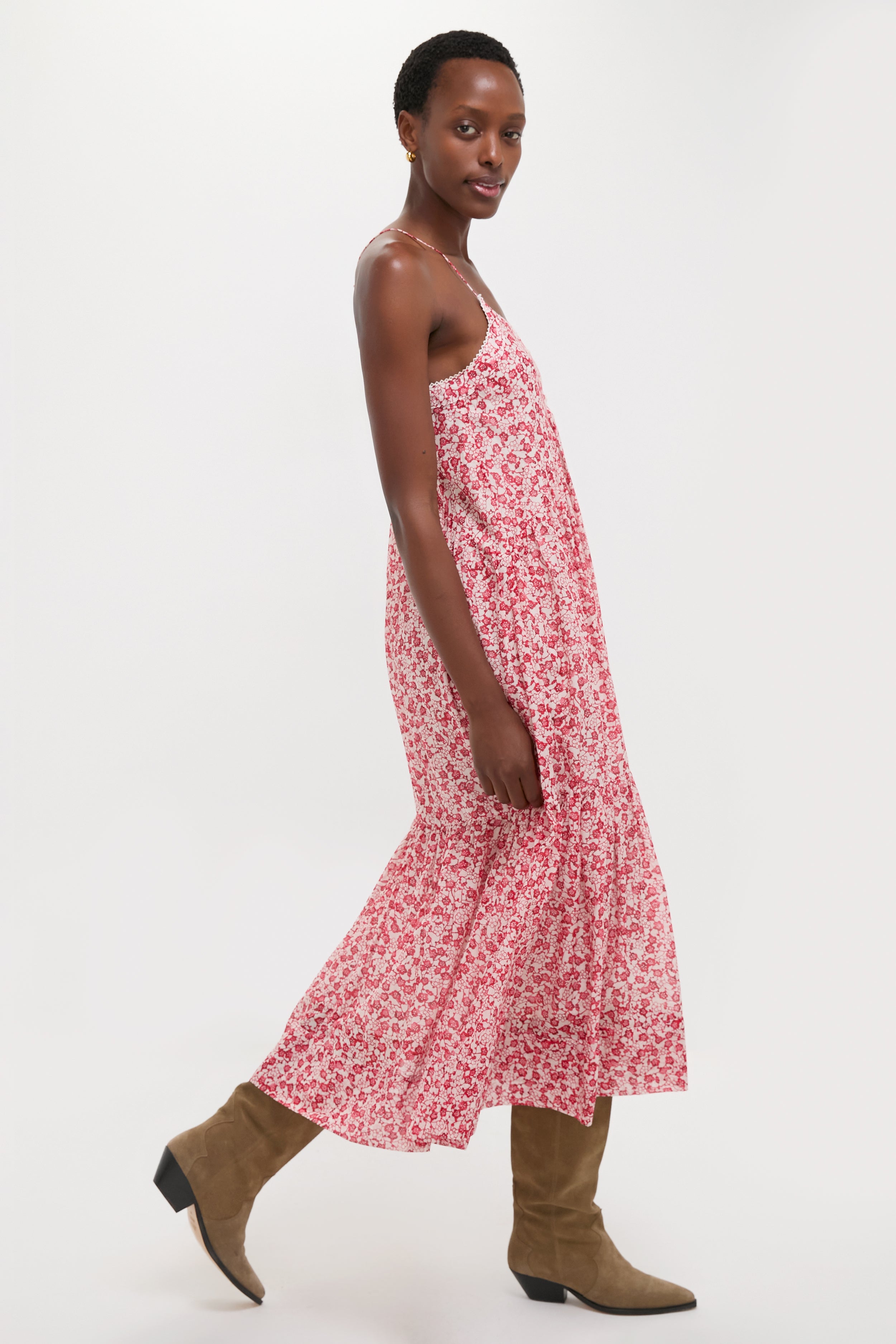 Effortlessly chic, the Red Sabba Dress features a classic, tiered silhouette and red floral print, styled with fun, high-end cowboy boots for any occasion.