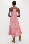 Person in a classic Red Sabba Dress with a tiered silhouette and spaghetti straps, styled effortlessly with suede boots for a fun, high-end look.