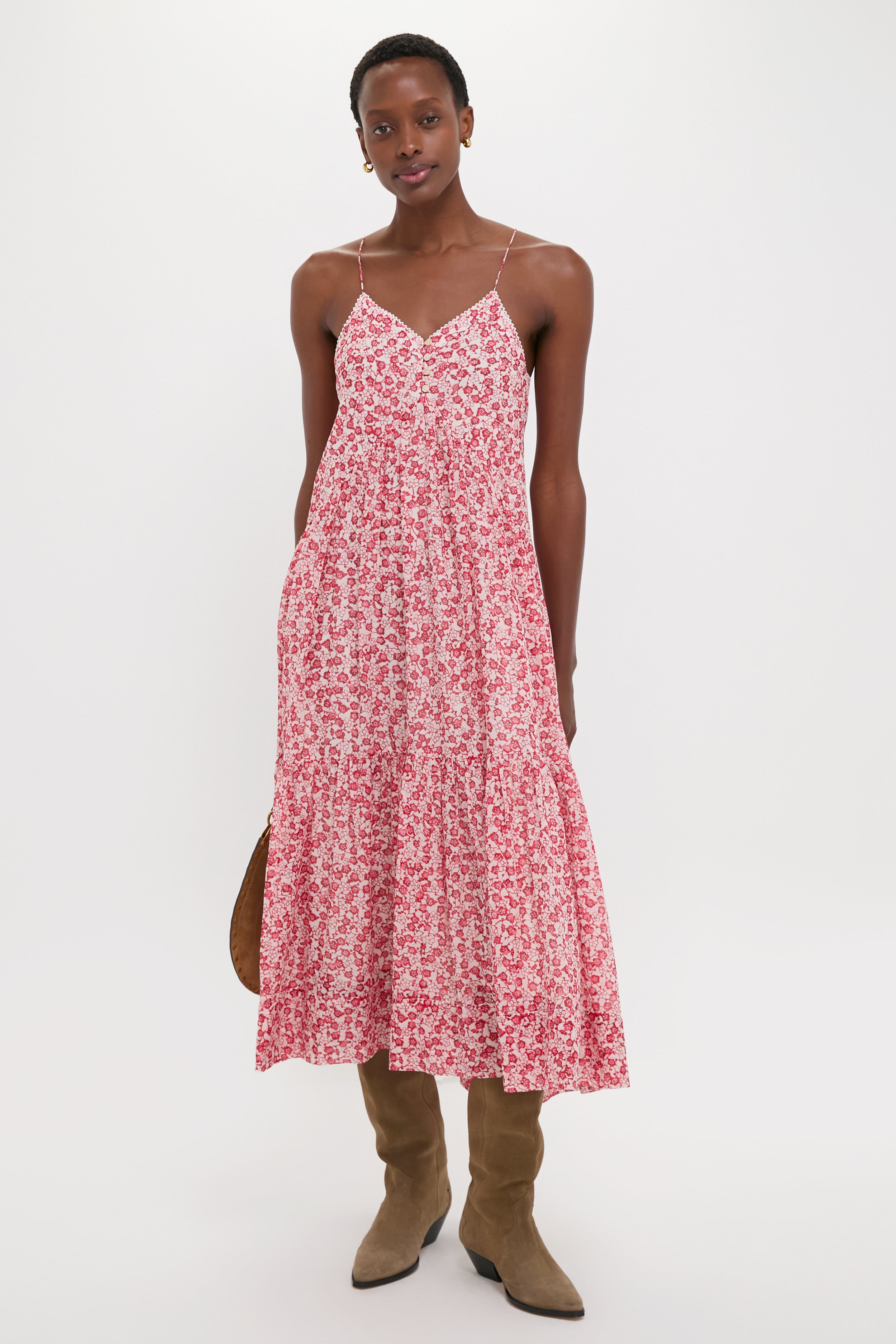 Effortlessly stylish, the Red Sabba Dress features a classic floral print, tiered design, and slim straps, paired with knee-high suede boots for a high-end, fun look.