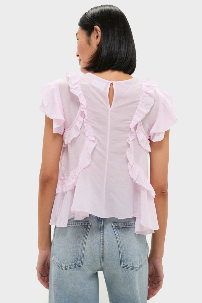 Person wearing the classic Light Pink Nalou Top with flutter sleeves and ruffle detailing, paired with light-wash jeans. An effortlessly high-end, fun look for everyday style.