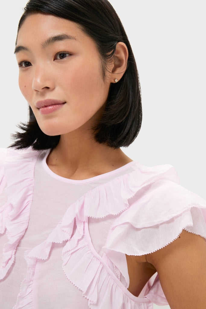 Young woman in a classic, high-end, pale pink Light Pink Nalou Top with ruffle and flutter sleeves, embodying an effortless, fun, and confident style.