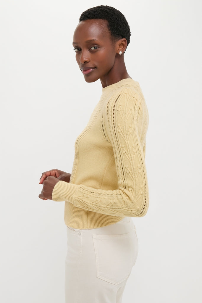 Light Yellow Kalyn Sweater with cable knit sleeves, pleated shoulders, and ribbed hem, embodies classic, effortless style. Ideal for a chic, high-end, fun look.