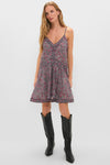 Woman in Crushed Berry Danielle Dress—classic, floral, sleeveless with V-neck—paired effortlessly with high-end black leather boots. Fun, relaxed resort-ready style.