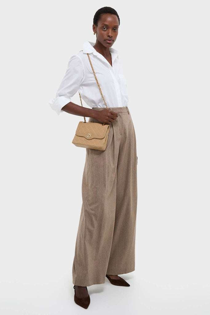 Model showcasing the classic CHANEL CC Mini Paris Double Flap Bag, evoking an effortless and high-end style with a quilted design and gold-tone chain.