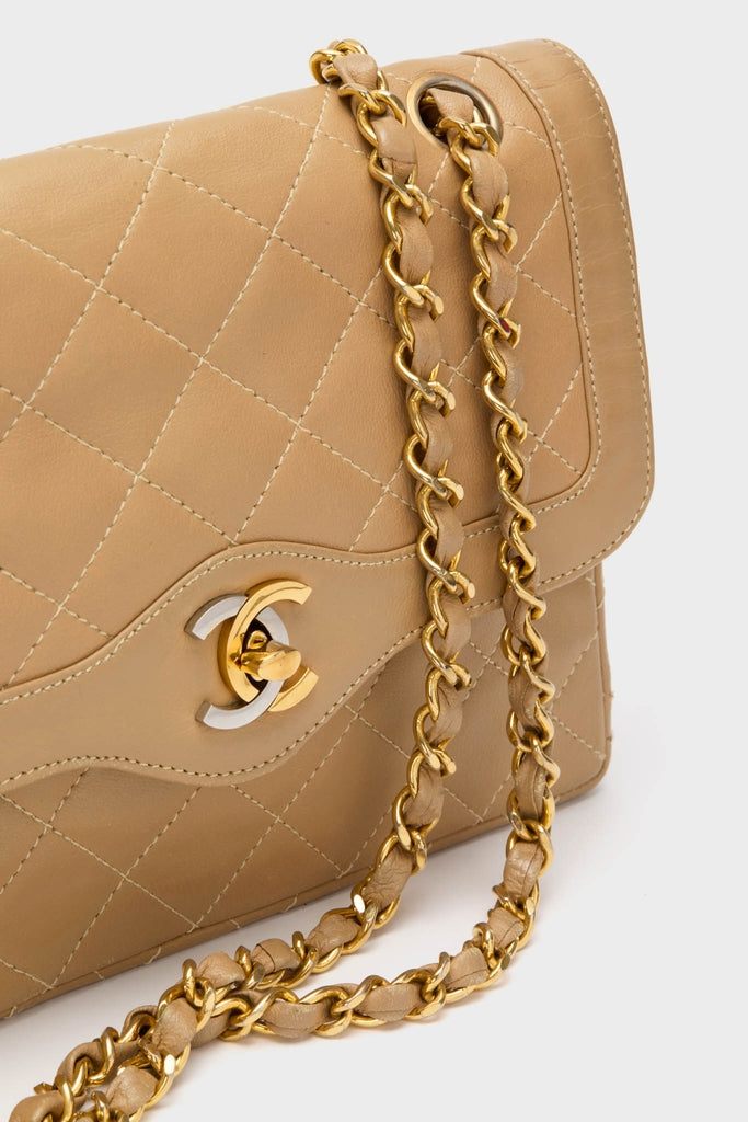 CHANEL CC Mini Paris Double Flap Bag, a classic and high-end quilted tan-beige leather piece, features an effortless woven leather-and-gold chain strap and interlocking CC clasp.