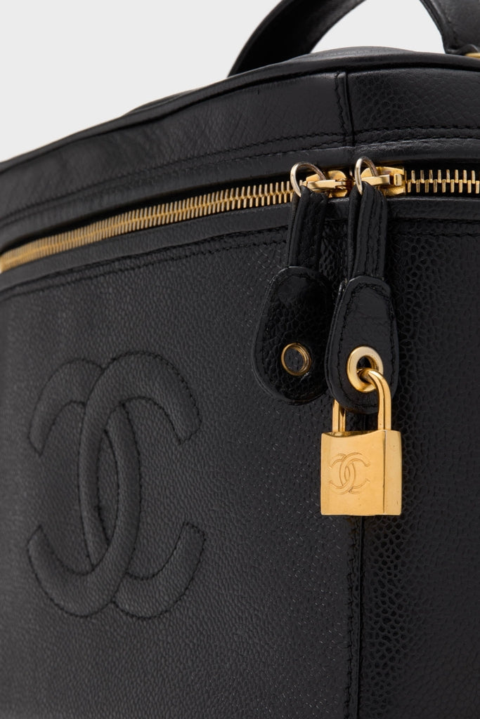 CHANEL Large Caviar Vanity Bag in black pebbled leather, featuring a classic interlocking “CC” logo, gold-tone zipper, and padlock, embodying effortless, high-end style.