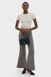 Model showcasing an effortless, high-end ensemble with CHANEL Navy Blue Lambskin Double Flap handbag, paired with classic plaid trousers and fun, pointed-toe heels.