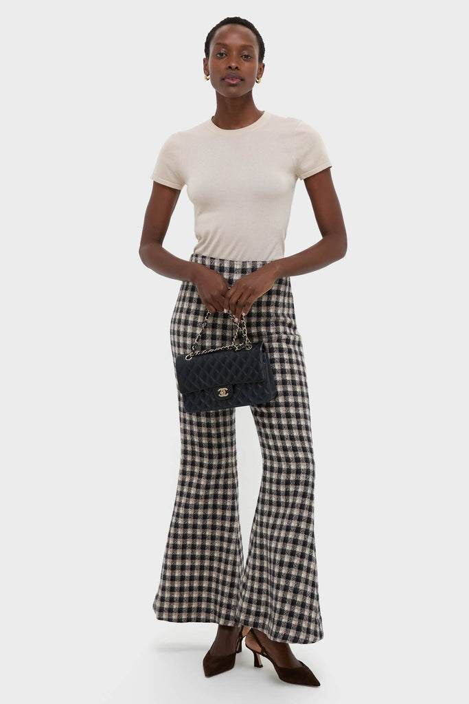 Model showcasing an effortless, high-end ensemble with CHANEL Navy Blue Lambskin Double Flap handbag, paired with classic plaid trousers and fun, pointed-toe heels.