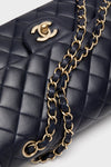 CHANEL Navy Blue Lambskin Double Flap bag with classic diamond stitching, gold-tone chain strap, and iconic interlocking CC clasp, embodying effortless, high-end style.