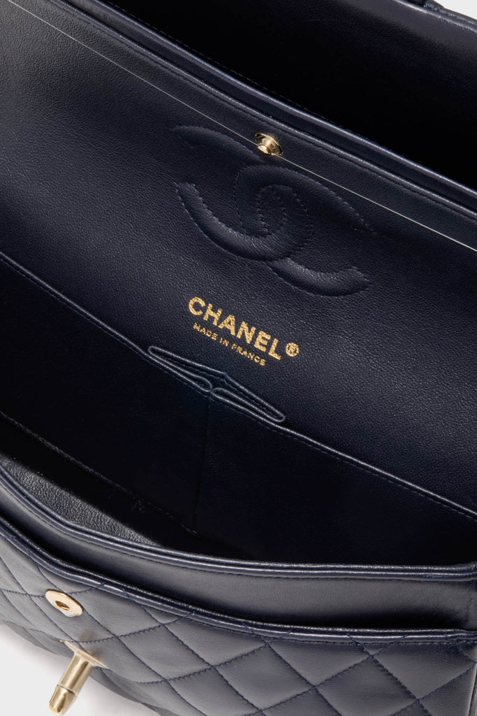 Classic CHANEL Navy Blue Lambskin Double Flap bag interior, featuring navy leather lining, stitched CC logo, and gold CHANEL Made in France stamp, exuding effortless, high-end elegance.