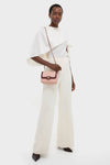 Dark-skinned model showcases an effortless, high-end look with a CHANEL Pink Lambskin Quilted Mini Two Tone Day Flap Shoulder Bag, exuding classic style and fun elegance.