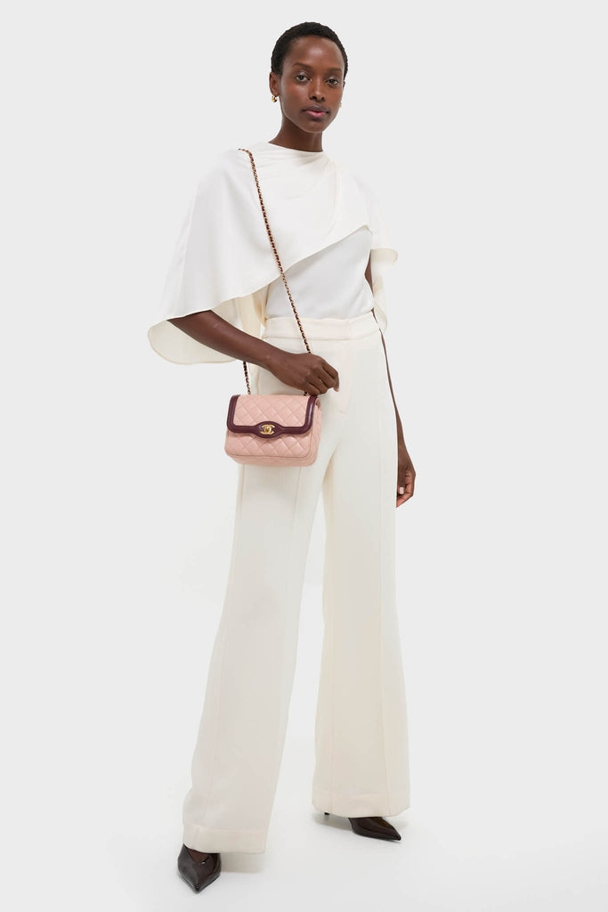 Dark-skinned model showcases an effortless, high-end look with a CHANEL Pink Lambskin Quilted Mini Two Tone Day Flap Shoulder Bag, exuding classic style and fun elegance.