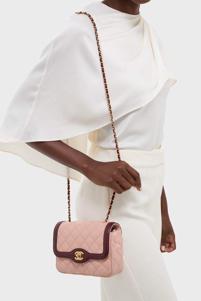 Effortlessly chic, the CHANEL Pink Lambskin Quilted Mini Two Tone Day Flap Shoulder Bag exudes high-end style with its classic gold CC clasp and fun chain strap.