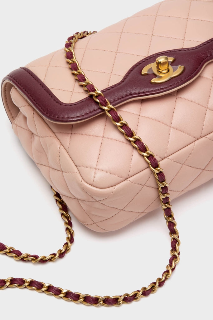 CHANEL Pink Lambskin Quilted Mini Two Tone Day Flap Shoulder Bag, featuring a classic burgundy leather-trimmed flap with a gold turn-lock clasp and an effortless gold chain strap.