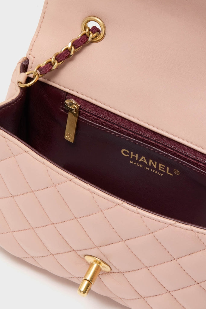 CHANEL Pink Lambskin Quilted Mini Two Tone Day Flap Shoulder Bag with burgundy lining, zip pocket, and classic gold chain strap, exuding effortless, fun, high-end style.