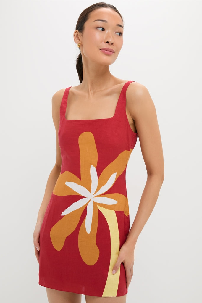 Model wearing the classic Cattleya Carmin Siela Dress, a sleeveless, high-end red mini with a square neckline and bold floral graphic, perfect for effortless, fun style.