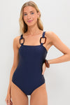 Model in classic Navy Colsid Straps Swimsuit with square neckline and tortoise details, exuding effortless elegance. Paired with a matching bracelet for a high-end, fun look.