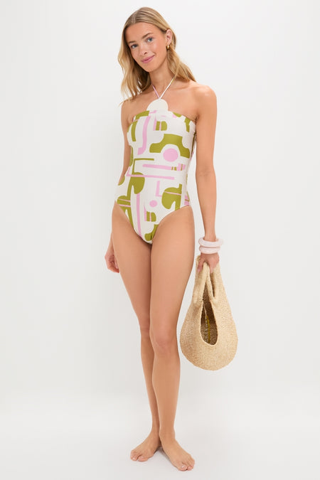 Young woman in an Off-White Balearic Applique Swimsuit, holding a straw tote, embodies classic, effortless style with fun, high-end appeal.