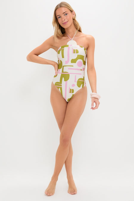 Woman in Off-White Balearic Applique Swimsuit with geometric print, exuding classic, effortless style; accessorized with hoop earrings and scrunchie. Perfect for fun, high-end beachwear.