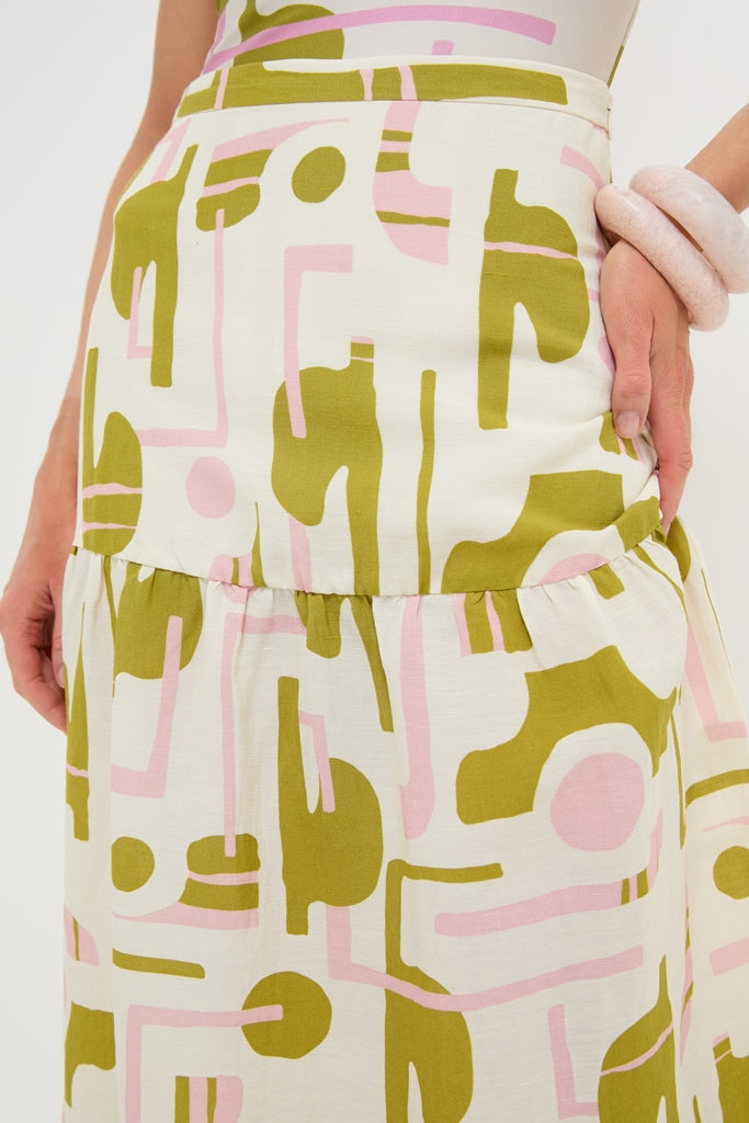 Off-White Balearic Midi Skirt in cream features an abstract olive green and pale pink pattern, fitted waist, and gathered tier, exuding classic, effortless, and high-end style.