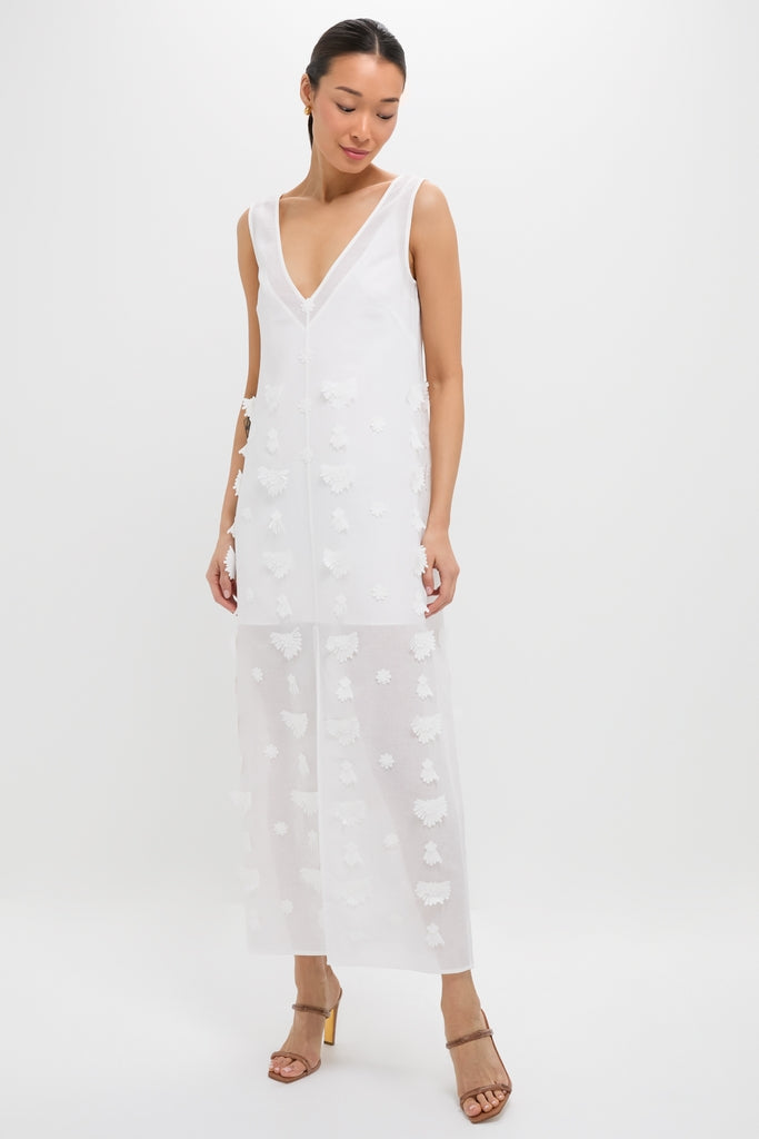 Woman in Off White Aria Embroidery Midi Dress with floral appliqués, deep V-neckline, sheer skirt, and brown block-heel sandals, embodying an effortless and high-end style.