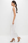 Woman in profile wearing the Off White Aria Embroidery Midi Dress with floral appliqués, paired with strappy high-heeled sandals, exuding a classic and effortless high-end style.