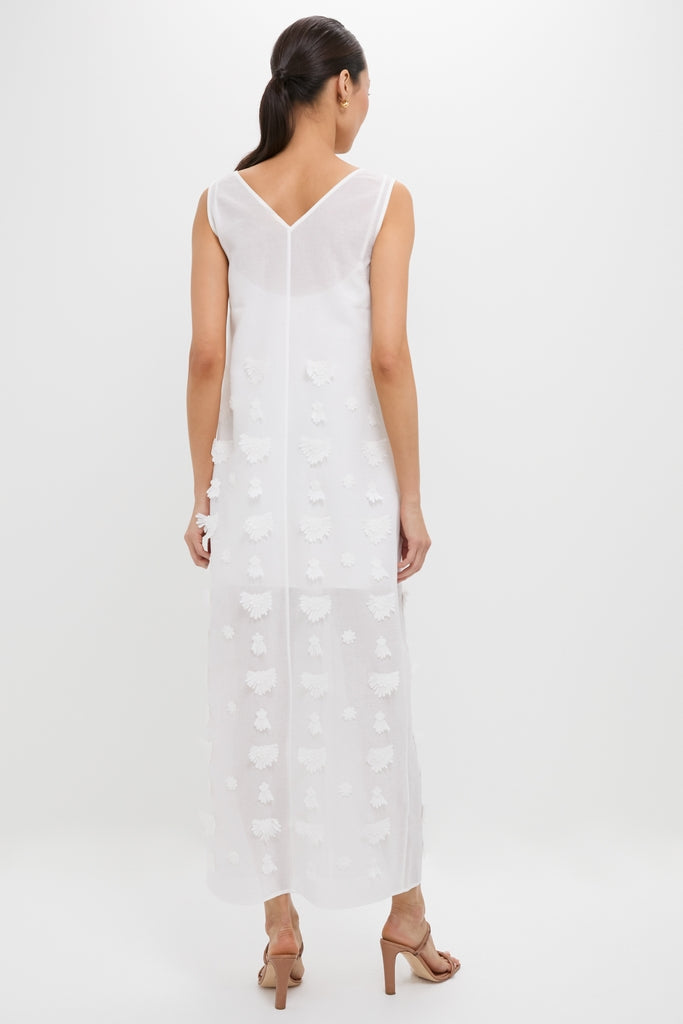 Woman wearing the Off White Aria Embroidery Midi Dress, featuring a classic V-shaped back and three-dimensional floral appliqués, styled with effortless high-end elegance and fun strappy sandals.