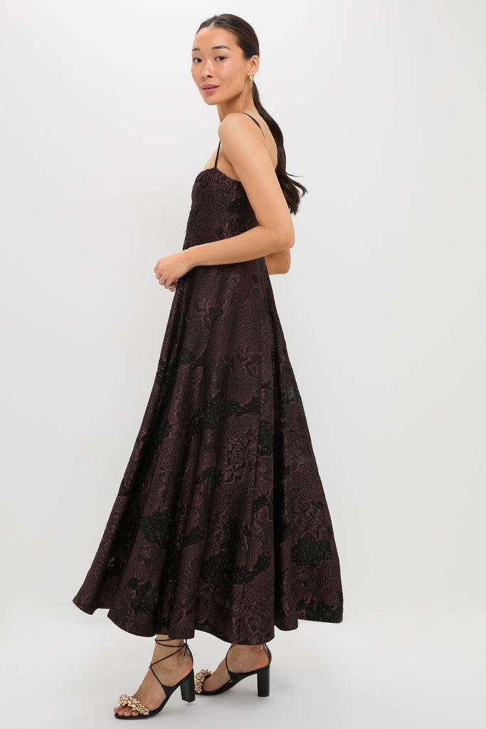 Model in Arabica Jacquard Theron Midi Dress, featuring classic dark jacquard with black floral patterns, paired with effortless block-heel sandals, embodying Tuckernuck's fun, high-end style.