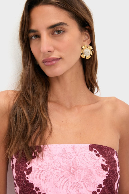 Young woman wearing a strapless top and an oversized flower earring, showcasing the effortless, high-end Blush and Maroon Abstract Bennet Midi Dress, embodying classic and fun Tuckernuck style.