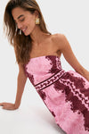 Young woman in a Blush and Maroon Abstract Bennet Midi Dress, effortlessly combining classic style with fun elegance, featuring a striking floral earring for a high-end look.