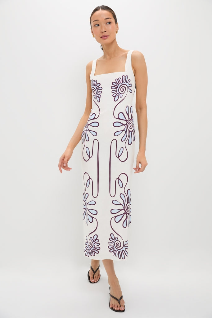 Model wearing the Namur Celeste Amaranta Dress, a classic, effortlessly chic midi dress with abstract floral motifs, paired with black strappy sandals and gold hoop earrings.