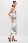 Namur Celeste Amaranta Dress: A classic, sleeveless white dress with abstract purple spirals, offering an effortless, high-end look, paired with fun black heeled thong sandals.