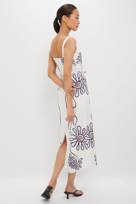 Model in profile wearing the classic Namur Celeste Amaranta Dress, featuring abstract motifs and a side slit, paired with effortless black mules for a high-end, fun look.