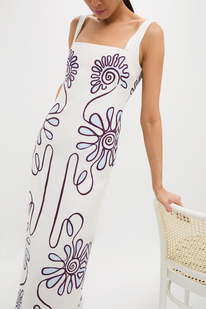 Woman wearing the Namur Celeste Amaranta Dress, a classic, high-end, floor-length white dress with abstract floral motifs; an effortless and fun style from Tuckernuck.