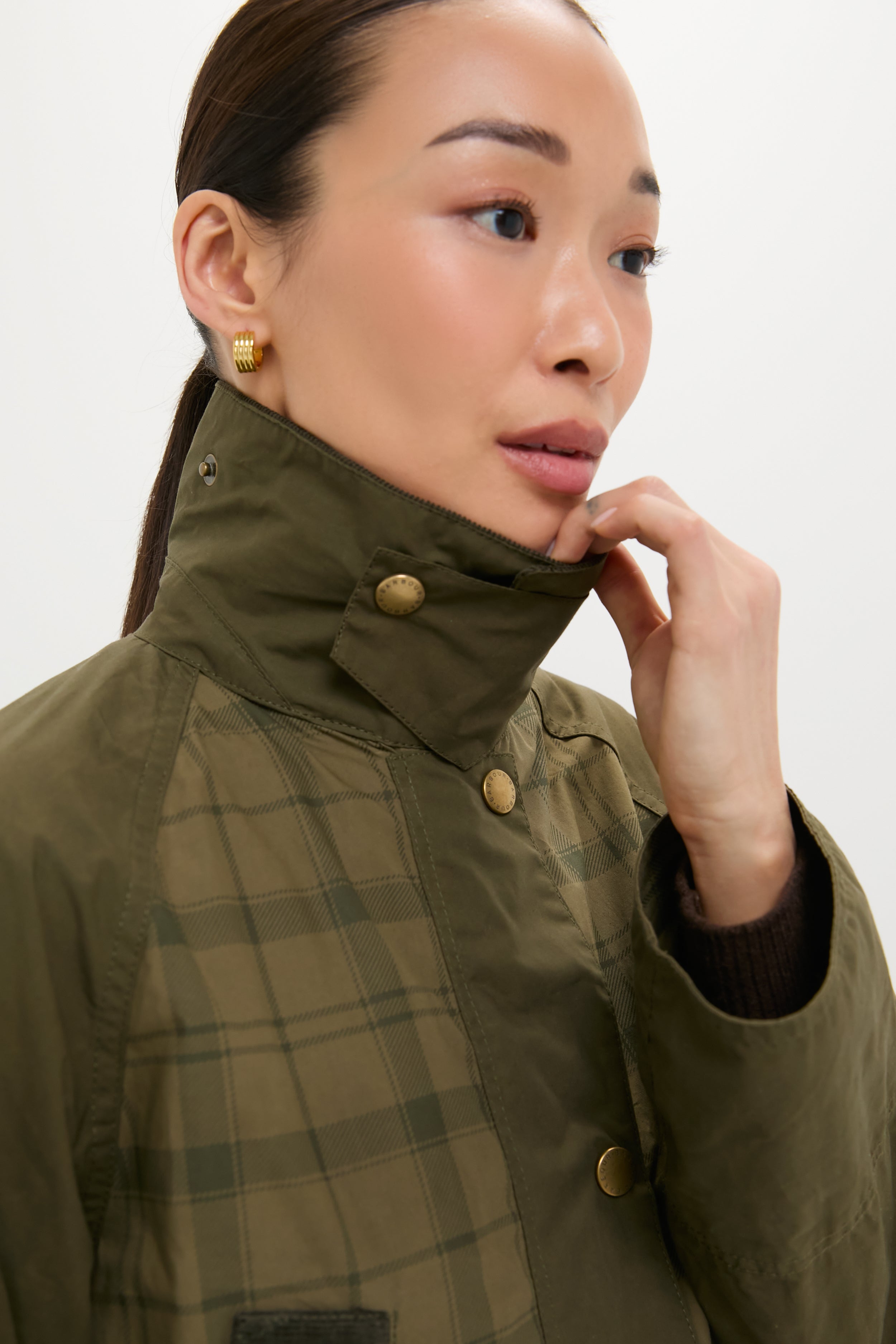 Woman models the Dusky Green Modern Tartan Beadnell Casual Jacket, showcasing its classic plaid design, high collar, and relaxed fit for an effortless, high-end look.