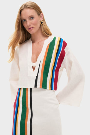 Model wearing the Roman Sassari Top, a classic and effortless white linen blouse with colorful stripes, paired with a matching skirt, embodying a high-end, fun style.
