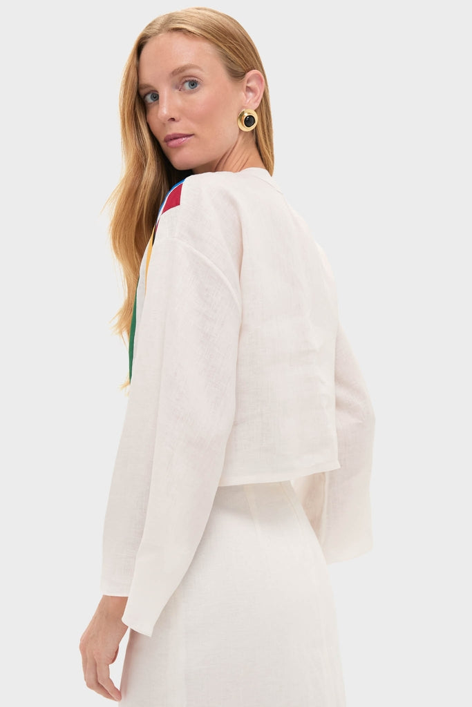 Model in profile wearing the Roman Sassari Top, a classic white linen crop with colorful shoulder panels, paired with a matching high-waisted skirt for an effortless, high-end look.