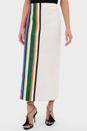 Roman Lima Midi Skirt: A classic, high-waisted, ankle-length white skirt with colorful vertical stripes, paired with effortless, fun, high-end black strappy sandals featuring tassel details.