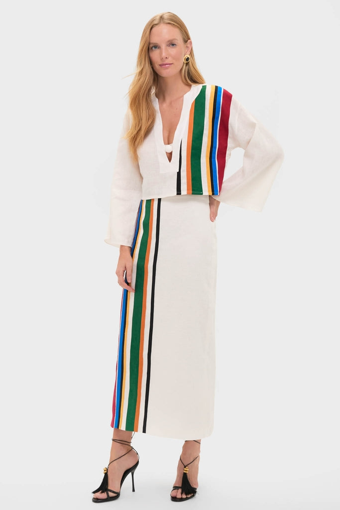 Model wearing the Roman Lima Midi Skirt, an off-white, high-end two-piece with classic vertical stripes, embodying effortless fun and elegance, paired with black strappy heels.