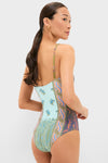 Woman modeling the Pastel Patchwork Lucent One Piece swimsuit, showcasing a classic, scooped-back design with an effortless multicolored paisley print, embodying high-end, fun beachwear.