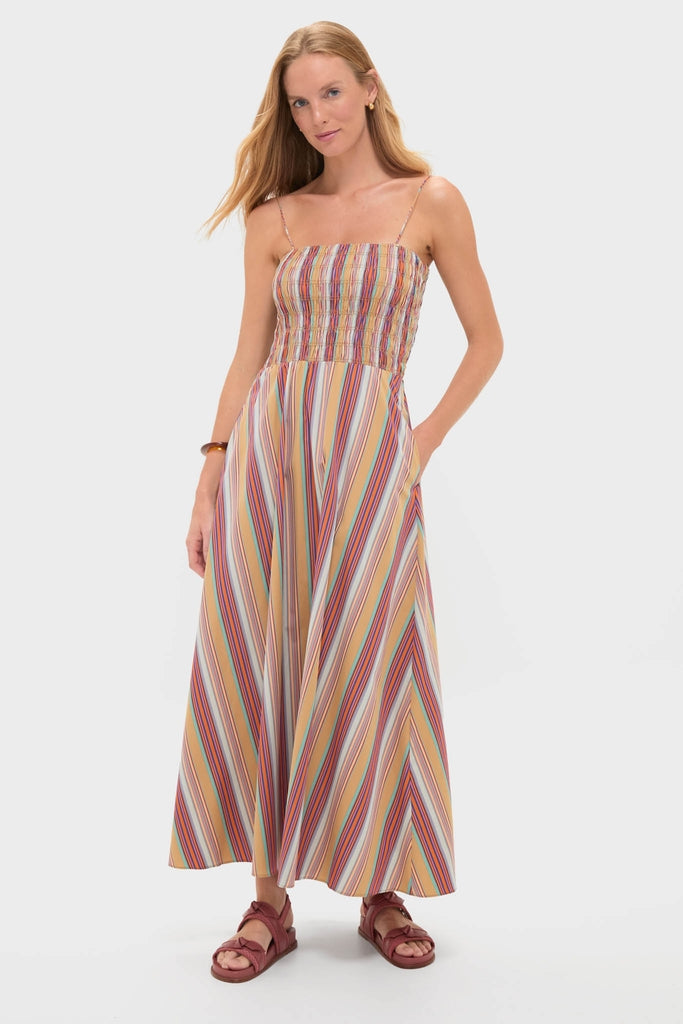 Model wearing the Mustard Agua Stripe Annikekn Maxi Dress with a shirred bodice and A-line skirt, styled with rust-red sandals, embodying effortless, high-end fashion.