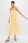 Woman in a classic, effortless Banana Lopez Midi Dress with a relaxed A-line silhouette, adjustable straps, and box pleats, styled with fun, high-end strappy sandals.