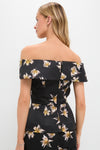 Woman wearing the Black and Yellow Souline Top, an off-the-shoulder piece with light lily pattern, embodying a classic and effortless high-end style, paired with matching bottoms.