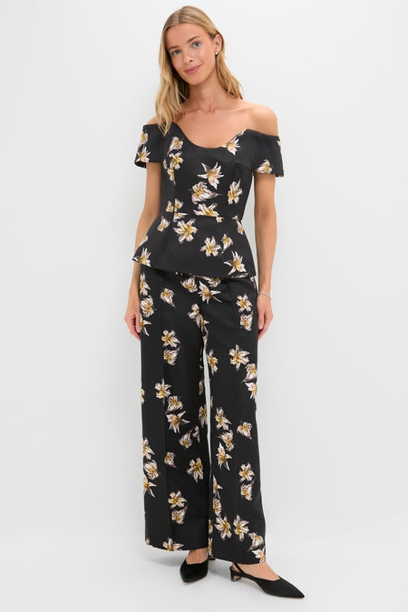 Woman models the Black and Yellow Souline Top, a classic, high-end off-the-shoulder peplum with effortless floral print, paired with matching trousers for a fun, coordinated look.