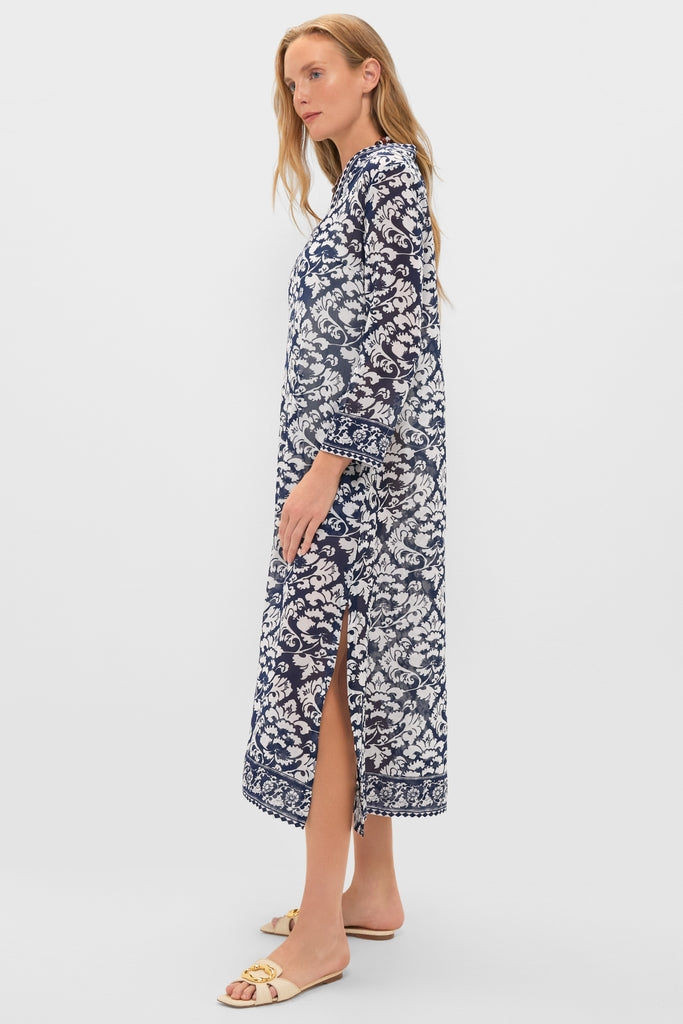Model showcases the classic Dark Blue Giada Caftan, an effortless, high-end maxi dress with a fun navy-and-white print, side slit, and contrasting border details.