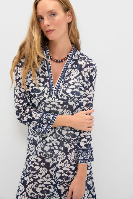 Woman in the classic Dark Blue Giada Caftan with a floral pattern, exuding effortless elegance. She accessorizes with a beaded necklace, embodying a fun, high-end style.