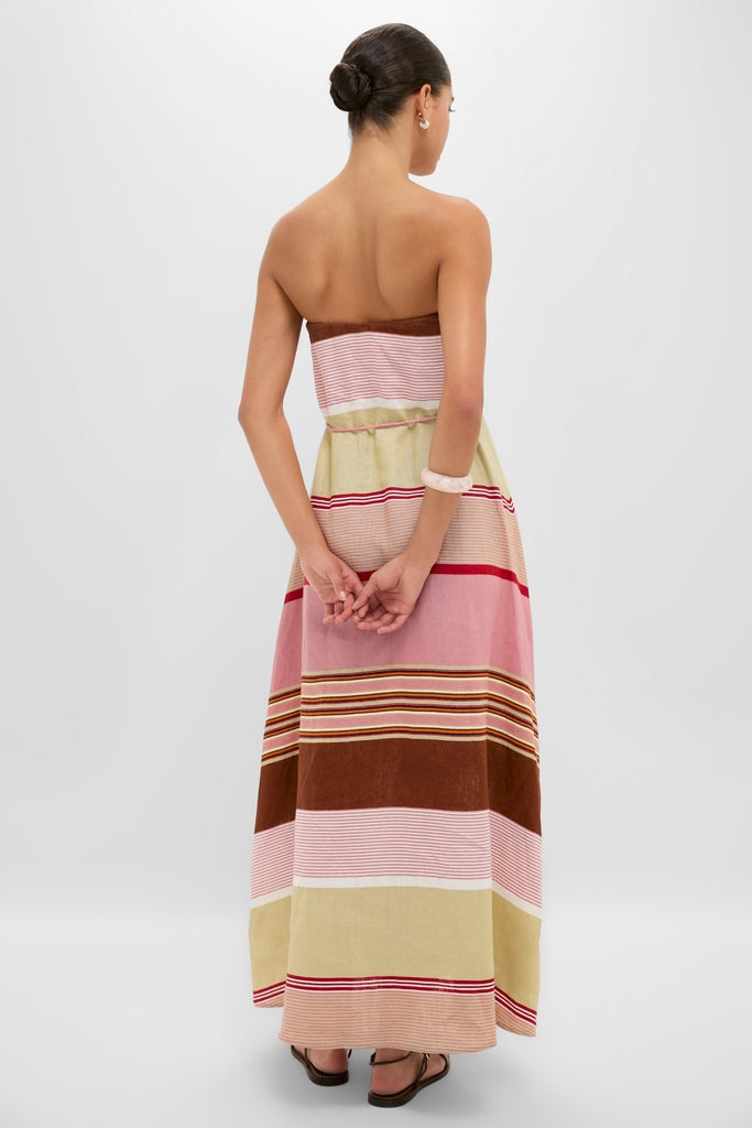 Woman in Dust Mauve Barragan Stripe Yolina Maxi Dress, showcasing an effortless, classic style with strapless design and relaxed A-line silhouette, embodying high-end, fun vacation vibes.