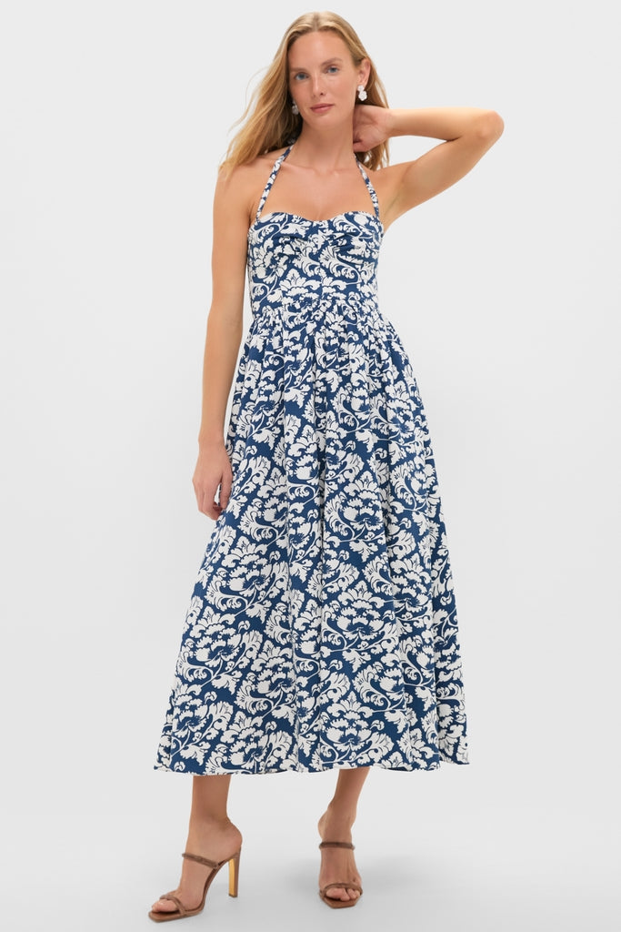 Young woman in a classic, effortless Dark Blue Johanna Midi Dress with a sweetheart neckline and full A-line skirt, paired with fun, high-end brown heeled sandals.