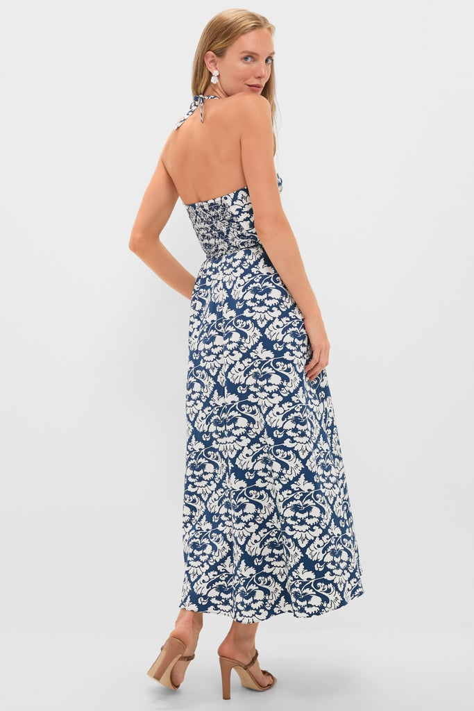 Woman modeling the classic Dark Blue Johanna Midi Dress with an effortless halter-neck design, featuring a fun floral pattern and high-end smocked bodice, exuding confidence and sophistication.